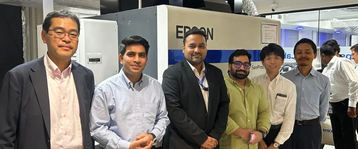 Epson executives and guests at the ribbon-cutting ceremony for the SurePress L-6534VW UV inkjet label press launch in New Delhi, with live demo in background.
